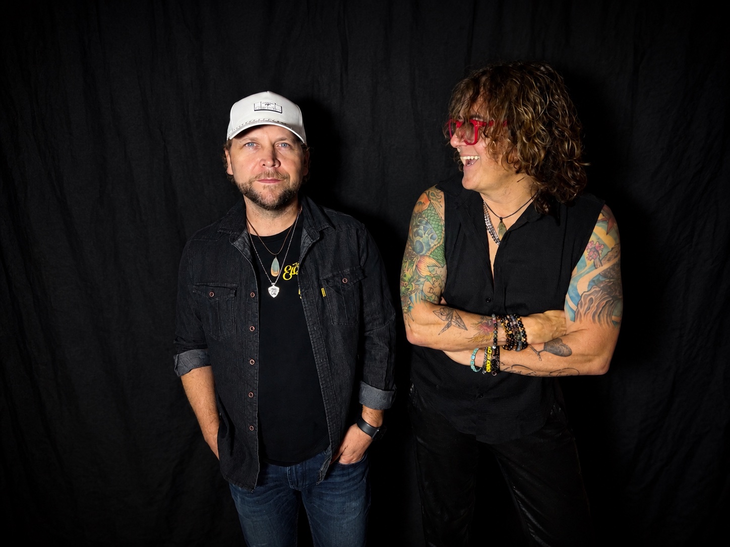 Two members of Jet Lag Motel posing against a black backdrop
